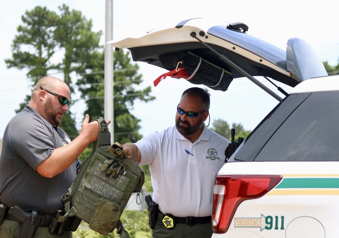 St. Johns County Sheriff’s Office Cpl. Greg Suchy (right) checks out tactical gear with Dep. Jared Goodman in the parking lot of St. Augustine High School. Both Suchy and Goodman are Youth Resource Deputies for the Sheriff’s Office. [TRAVIS GIBSON/THE RECORD]
