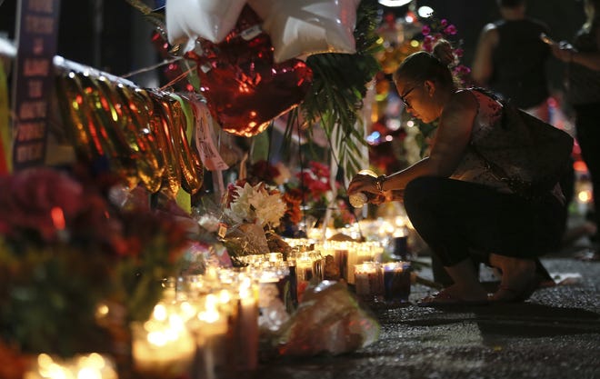 Roxana Jaquez lights a candle at an ever growing memorial this week outside the Walmart in El Paso, Texas, where a mass shooting took place on Saturday. [MARK LAMBIE/THE EL PASO TIMES]