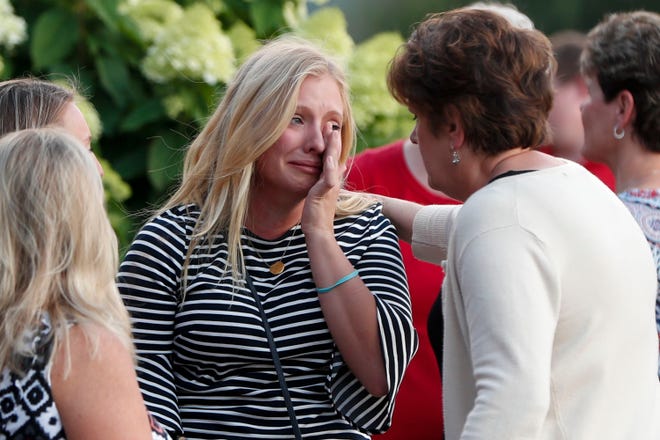 Mourners console each other after a mass in the chapel on the campus of Saint Francis University to celebrate the life of Nicholas Cumer on Tuesday, Aug. 6, 2019, in Loretto, Pa. Cumer was a graduate student in the master of cancer care program at the University and was among those killed in the Dayton shooting early Sunday. (AP Photo/Keith Srakocic)