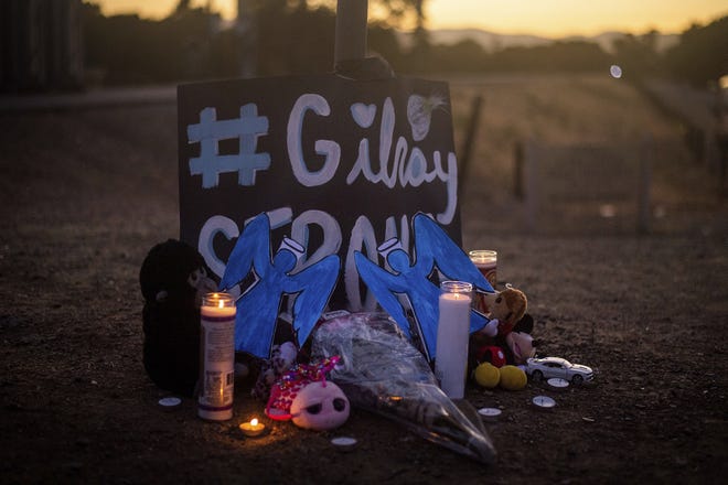 Candles burn at a makeshift memorial for Gilroy Garlic Festival shooting victims outside the festival grounds. [NOAH BERGER/AP]
