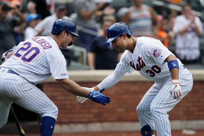 Mets' Michael Conforto, right, is greeted by teammate Pete Alonso after hitting a solo run home run against the Marlins in the seventh inning.