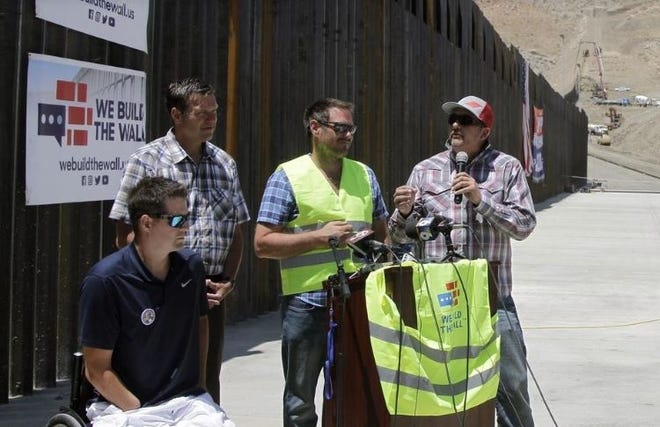 In this May 30 photo, leaders of nonprofit We Build The Wall Inc., including Brian Kolfage, left, discuss plans for constructing wall sections along the U.S.-Mexico border. Legal issues are continuing to dog the nonprofit organization. [AP PHOTO]