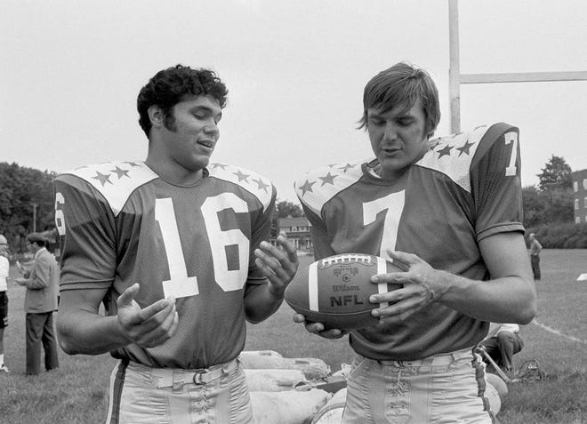 In this July 9, 1971 photo, College All-Star quarterbacks Jim Plunkett (16) and Dan Pastorini (7) talk at practice in Evanston, Ill., for a charity game against the Baltimore Colts to be played July 30, 1971, in Chicago. [AP PHOTO/CHARLES E. KNOBLOCK]