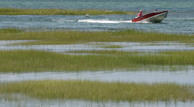 A boat weaves between the marshes near Grays Beach on a warm afternoon.