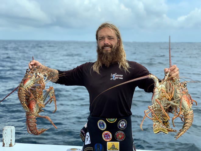 Emerald Coast Scuba Master Instructor Jason Dodd holds up six spiny lobsters captured during the opening day of lobster season. [ANNA SCHMITZ/CONTRIBUTED PHOTO]