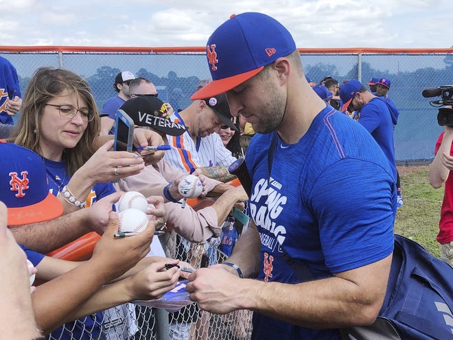 Tim Tebow signs autographs at spring training in Port St. Lucie. Tebow is expected to miss the rest of the season with a hand injury. [AP Photo/Mike Fitzpatrick]