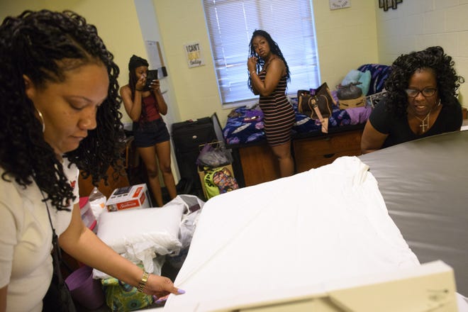 Shanta Reddick, right, and her sister, Crystal Harvey, left, make a bed for Reddick's daughter, Caryn Fletcher, as they prepare her dorm room for move-in at Fayetteville State University on Saturday, Aug. 10, 2019. [Melissa Sue Gerrits/The Fayetteville Observer]