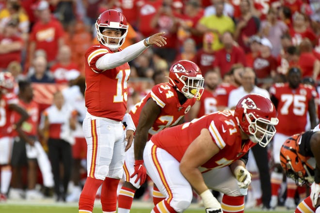 Kansas City Chiefs quarterback Patrick Mahomes (15) calls a play at the line of scrimmage behind offensive tackle Mitchell Schwartz (71), during the first half of a preseason game against the Cincinnati Bengals in Kansas City, Mo., on Saturday. [ED ZURGA/THE ASSOCIATED PRESS]