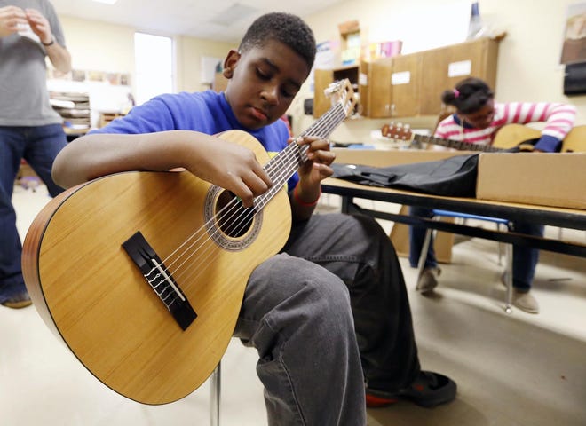 Devin Rollins, 11, a student at Martin Luther King Jr. Elementary School, learns to play guitar during the first day of the 10 week Alabama Blues Project After School Camp hosted at Martin Luther King Jr. Elementary School Tuesday, Feb. 4, 2014. [File staff photo]