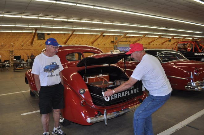 Nelson Creasy, right, along with his brother Larry, left, show how easy the 1937 Hudson Terraplane Utility trunk cart is to operate at the recent Bloomsburg Nationals in Bloomsburg, Pennsylvania. These Utility Coupes were popular back in the late 1930s and offered owners easy access to items stored further back in the trunk. [Greg Zyla]