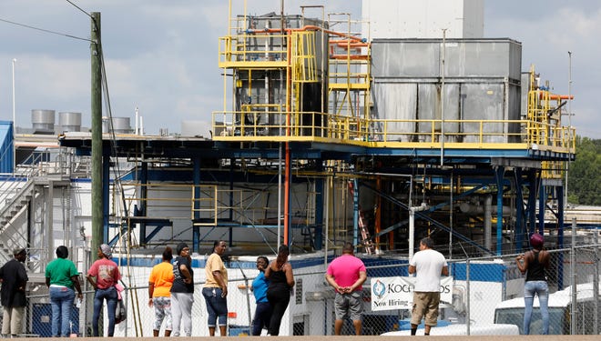 Friends, coworkers and family watch as U.S. immigration officials raid several Mississippi food processing plants, including this Koch Foods Inc., plant in Morton, Miss., Wednesday, Aug. 7, 2019. The early morning raids were part of a large-scale operation targeting owners as well as undocumented employees. (AP Photo/Rogelio V. Solis)