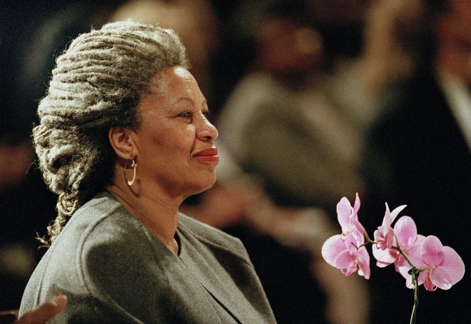 FILE - In this April 5, 1994 file photo, Toni Morrison as she holds an orchid at the Cathedral of St. John the Divine in New York.  The Nobel Prize-winning author has died. Publisher Alfred A. Knopf says Morrison died Monday, Aug. 5, 2019 at Montefiore Medical Center in New York. She was 88. (AP Photo/Kathy Willens, File)