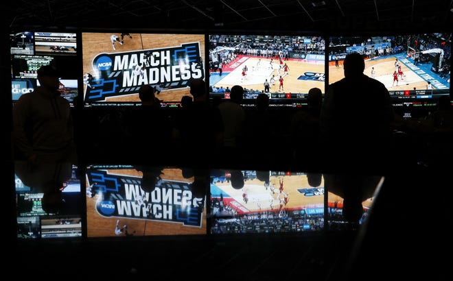 In this March 2018 photo, people watch coverage of the first round of the NCAA college basketball tournament at the Westgate Superbook sports book in Las Vegas. Following new enabling state legislation, Dover is among the New Hampshire communities exploring allowing sports betting to occur inside local businesses. [AP photo/John Locher, file]