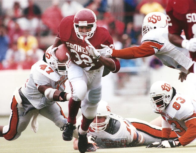 Oklahoma running back Mike Gaddis, center, runs past the outstretched arms of Oklahoma State defenders during the 1991 Bedlam game in Norman. The former Carl Albert High School standout ran for 203 yards on 35 carries on a rain-soaked Owen Field as the Sooners defeated the Cowboys, 21-6. [THE OKLAHOMAN ARCHIVES]