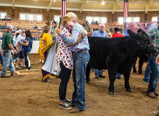 Cole Caldwell, of Peoria County, gets a hug from his mother Kim Caldwell, after his Grand Champion Steer was bought by Illinois First Lady M.K. Pritzker for $75,000 during the Governor´s Sale of Champions in the Coliseum of Champions at the Illinois State Fairgrounds, Tuesday, Aug. 13, 2019, in Springfield, Ill. [Justin L. Fowler/The State Journal-Register]