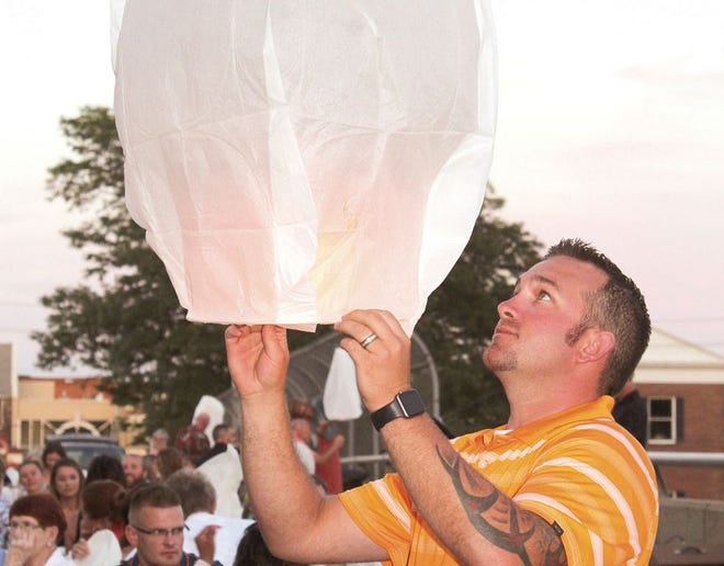 Zach Bliss of Three Rivers prepares to launch a lantern at “Dinner on the Bridge.”