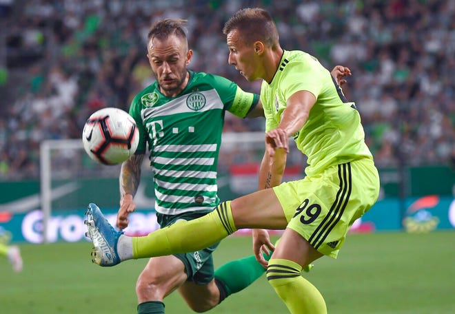 Ferencvaros' Gergely Lovrencsics, left, vies for the ball with Dinamo Zagrb's Mislav Orsic during the Champions League third qualifying round first leg soccer match between Ferencvaros and Dinamo Zagreb in Budapest, Hungary, Tuesday, Aug. 13, 2019. (Tibor Illyes/MTI via AP)