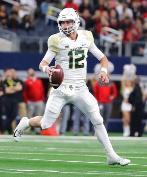 From Nov. 24, 2018, Baylor quarterback Charlie Brewer scrambles out of the pocket before throwing a pass in the first half of an NCAA college football game against Texas Tech in Arlington, Texas. (Jerry Larson/Waco Tribune-Herald via AP, file)