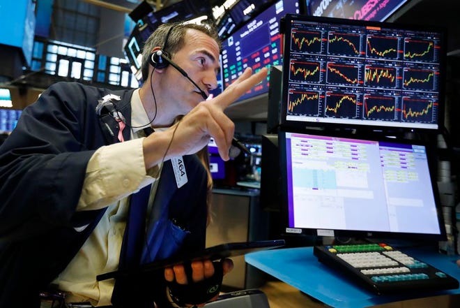In this July 30, 2019 file photo, trader Gregory Rowe works on the floor of the New York Stock Exchange. An economic alarm bell is sounding in the U.S. and sending warnings of a potential recession. Yields on 2-year and 10-year Treasury notes inverted early Wednesday, Aug. 14, a market phenomenon that shows investors want more in return for short-term government bonds than they are for long-term bonds.