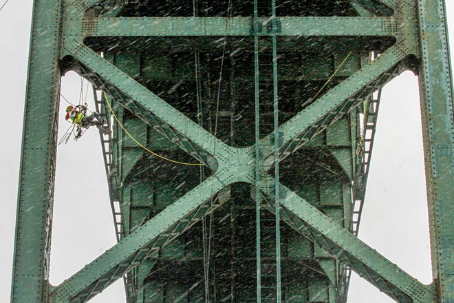 Technician Caleb Comstock of GEV Group is suspended in one of the Mount Hope Bridge's trusses during Tuesday's demonstration. [The Providence Journal / David DelPoio]