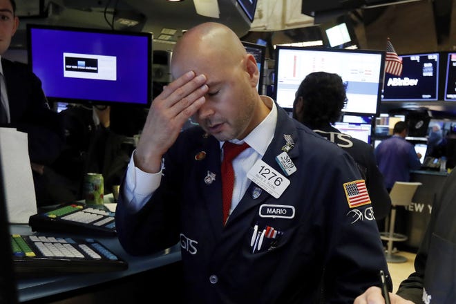 Specialist Mario Picone works on the floor of the New York Stock Exchange on Wednesday, Aug. 14, 2019. The Dow Jones Industrial Average sank 800 points after the bond market flashed a warning sign about a possible recession for the first time since 2007. [RICHARD DREW/THE ASSOCIATED PRESS]