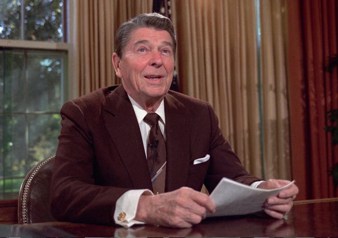 In this May 24, 1985, file photo, President Ronald Reagan works at his desk in the Oval Office of the White House as he prepares a speech on tax revision. [AP File Photo]