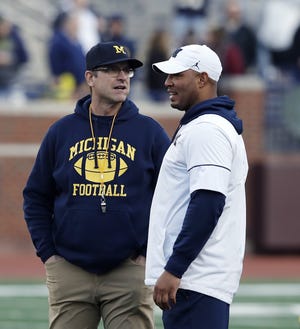 FILE- In this April 13, 2019, file photo Michigan head coach Jim Harbaugh, left, and offensive coordinator Josh Gattis talk during the team's annual spring NCAA college football game in Ann Arbor, Mich. Harbaugh seems to be set up for success at Michigan in his fifth season, leading a program that is a popular choice to win the Big Ten. (AP Photo/Carlos Osorio, File)