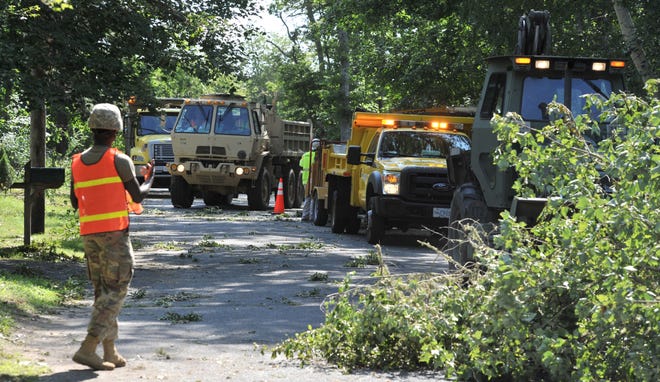 Army National Guard equipment fills Widow Stokes Road in Harwich clearing away trees after the July 23 tornadoes. Towns affected by the storms and the agencies that offered support added up their costs associated with the cleanup but fell short of the threshold for federal aid. [Steve Heaslip/Cape Cod Times file]