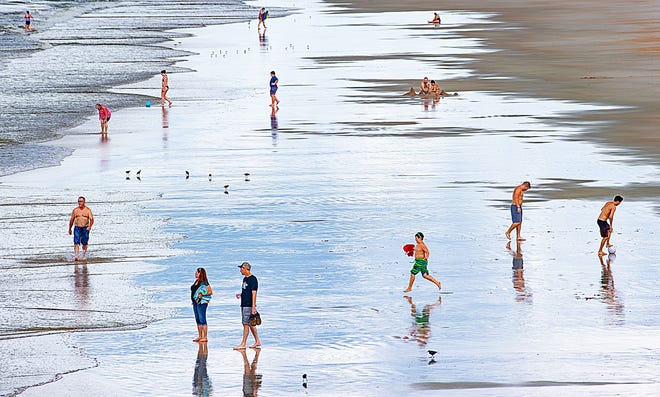Beachgoers enjoy Crescent Beach before heavy rain moved into the area on Thursday. [PETER WILLOTT/THE RECORD]
