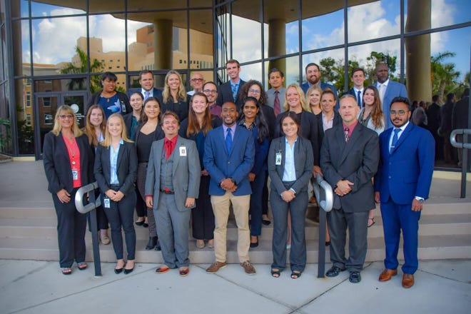 Fourteen college students and recent graduates pose with their assigned mentors outside the Manatee County administration building. The interns worked on a variety of summer projects. [Photo / Manatee County]