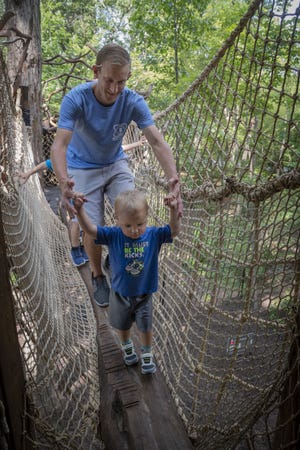 Nick Mulheim of Ohio helps son Marshall, 2, navigate the newly opened Treehouse Trek at the NC Zoo Friday, Aug. 16, 2019. [Paul Church / The Courier-Tribune]