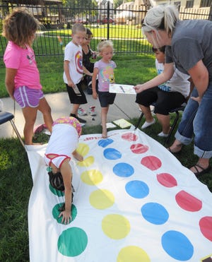 Children play twister and other games during the Second Annual Ashby House Block party on Saturday. The event featured free food, information from several nonprofit organizations and a dunk tank. [AARON ANDERS/SALINA JOURNAL]