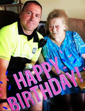 Quincy Police Community Officer Billy Mitchell stops by the home of Virginia Arlington to wish her a Happy 100th birthday.