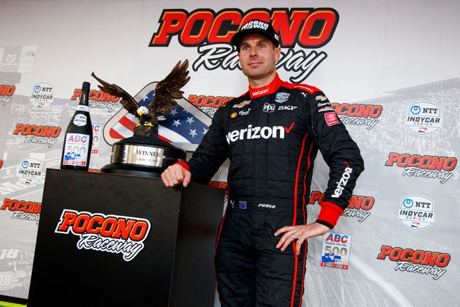 Will Power poses with the trophy after winning an IndyCar Series auto race at Pocono Raceway, Sunday, Aug. 18, 2019, in Long Pond, Pa. (AP Photo/Matt Slocum)