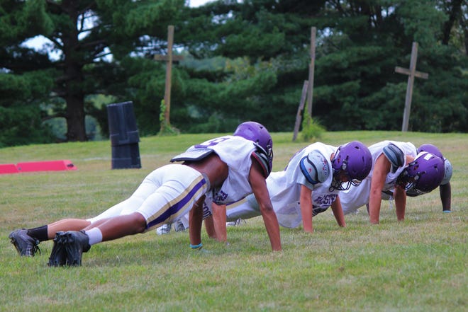 Western Beaver players do pushups during training camp in Ohio last week. [Mike Bires/BCT Staff]