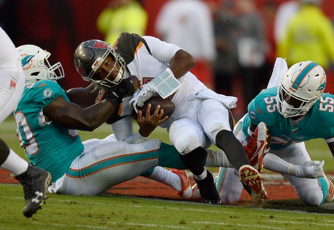 Dolphins defensive end Charles Harris (90) and outside linebacker Jerome Baker (55) team up to sack Tampa Bay Buccaneers quarterback Jameis Winston (3) during the first half. (AP Photo/Jason Behnken)