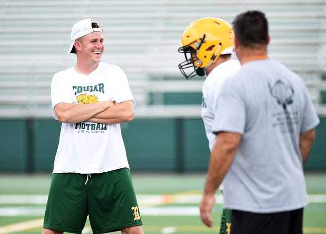 Blackhawk head coach Zach Hayward laughs with his coaches during a recent heat acclimation practice at the high school. [Lucy Schaly/For BCT]