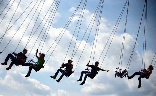 Riders on the Yo-Yo swing are silhouetted in the afternoon sky Tuesday on the first day at the Hookstown Fair. [Lucy Schaly/For BCT]