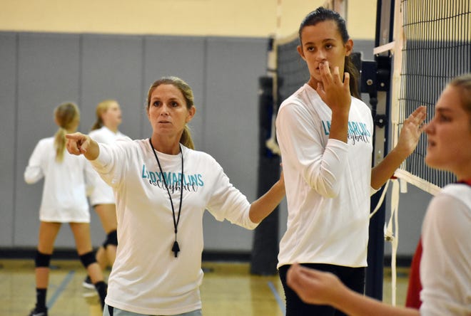 Destin Middle School Coach Susie Pierce gives instruction to Anna Kimball during practice Monday afternoon. [TINA HARBUCK/THE LOG]
