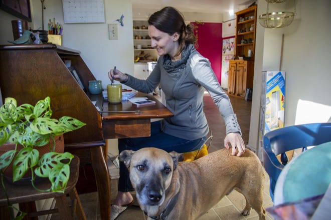 Local artist Jaimee Gentile, 31, and her dog Waffle spend their afternoons in the small dining room turned art studio. Gentile runs a small business, Paintings for Hummingbirds, out of her Eugene home.