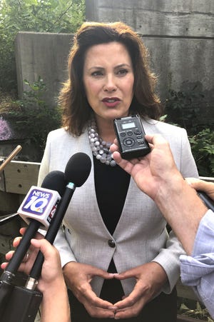 Gov. Gretchen Whitmer speaks with reporters after inspecting the Elm Street bridge over the Red Cedar River, Monday, Aug. 12, 2019, in Lansing. Whitmer recently visited Sault Ste Marie talking local officials, economic developers, manufacturers and businesspeople. (AP Photo/David Eggert)