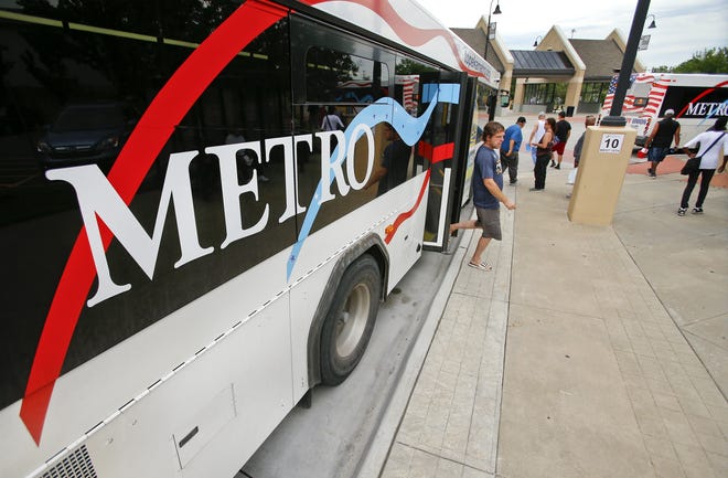Passengers get on and off of a Topeka Metro bus at the Quincy Street station Wednesday afternoon. [Chris Neal/The Capital-Journal]