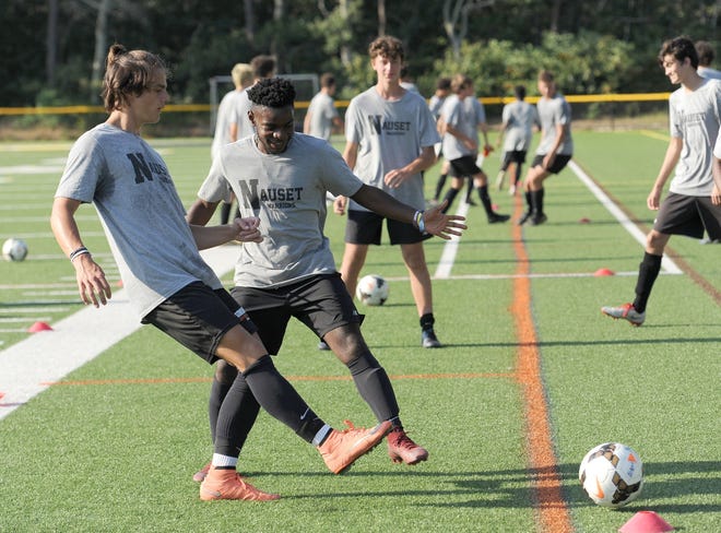 Seniors Sebastian Headrick, left, and Daryl Morris work through a drill during practice Thursday afternoon at Nauset Regional High School. Nauset will host Division 1 programs Ludlow, Weymouth and Hingham in a series of scrimmages starting at 10 Saturday morning. [Merrily Cassidy/Cape Cod Times]