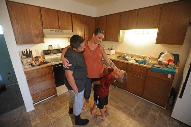 Misty Dotson hugs her son's at their home Tuesday, Aug. 20, in Murray, Utah. Dotson is a 33-year-old single mother of two boys, ages 12 and 6, who goes to Planned Parenthood for care through the Title X program. Dotson is among the 39,000 people received treatment from Planned Parenthood of Utah in 2018 under a federal family planning program called Title X. The organization this week announced it is pulling out program rather than abide by a new Trump administration rule prohibiting clinics from referring women for abortions.