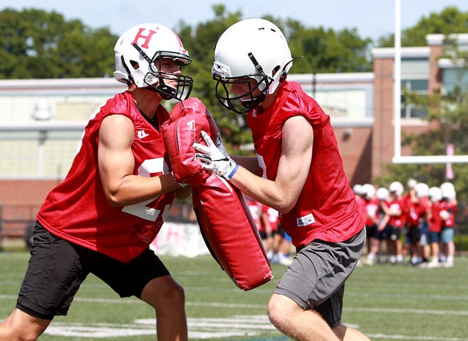 Junior Cooper Estes, right, goes in to block junior Patrick Petrillo, left, during a blocking exercise at practice on Friday, Aug. 16, 2019. [Wicked Local Staff Photo/ Robin Chan]