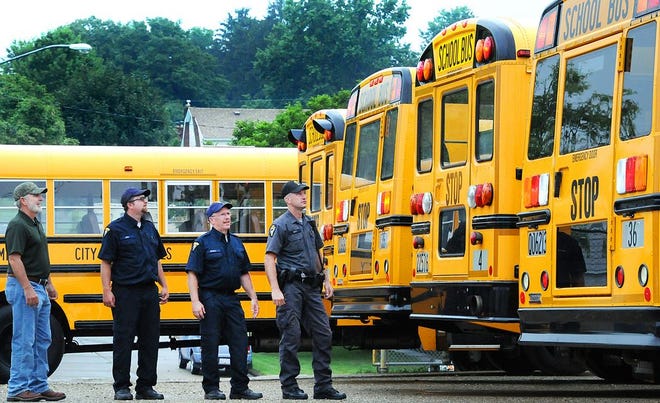 Cambridge City Schools Transportation Supervisor Dan Daugherty, left, checked out all the lights on these buses earlier this month to make sure they are in proper working order with Trooper Tim Scott, right, and motor vehicle inspectors Bryan Powell second from right, and Brennan King.