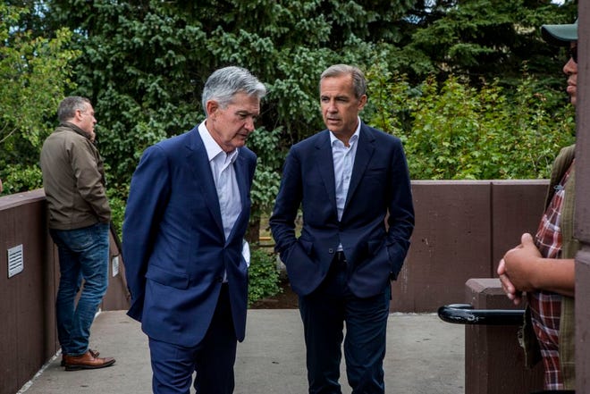 Federal Reserve Chairman Jerome Powell, left, and Bank of England Governor Mark Carney, right, walk together after Powell's speech at the Jackson Hole Economic Policy Symposium on Friday in Jackson Hole, Wyo.
