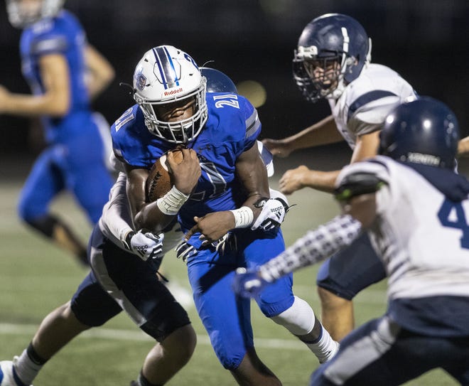 Lakeland Christian's Idris Williams is tackled by Oasis' Aiden Parilli during first-half action on Friday night at Viking Stadium in Lakeland. [ERNST PETERS/THE LEDGER]