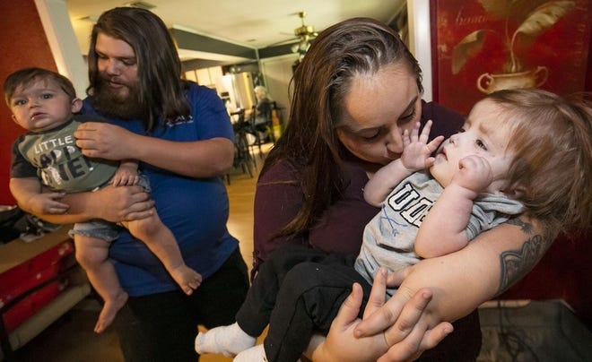 Beth Stimson, second from right, gives her son Oliver De Borde, 2, a kiss Tuesday afternoon as his younger brother Grayson and dad Justin De Borde, left, talk about how clothes and souvenirs were stolen from their vehicle in Macon, Georgia recently. Oliver was born with a heart defect that caused him to suffer severe brain damage. Beth Stimson, left, tickles her son Oliver De Borde. [DOUG ENGLE/OCALA STAR-BANNER]