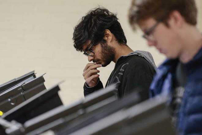 Ali Farooqui, a junior at Ohio Wesleyan University, pauses waile casting his ballot during Midterm Election Day on Tuesday, November 6, 2018 at Willis Education Center in Delaware, Ohio. More than 1,600 voters were mistakenly added to a list of registrations that could be purged because of a vendor error. [Joshua A. Bickel/The Columbus Dispatch file photo]